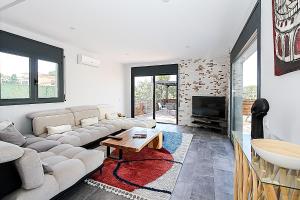a living room with a couch and a tv at Villa Esperanza in Vidreres