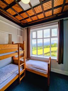 a bedroom with two bunk beds and a large window at YHA Windermere in Troutbeck