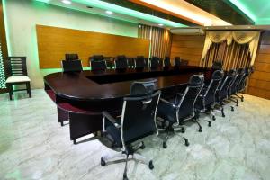 una gran sala de conferencias con una mesa larga y sillas en Hotel Orion International, en Jessore