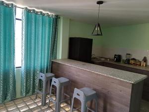 a kitchen with a counter and stools in a room at DEPARTAMENTO EN YANAHUARA 3er piso in Arequipa +6 photos