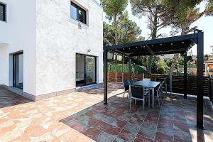 a patio with a table and chairs and a building at Villa Esperanza in Vidreres