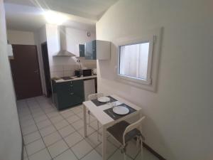 a small kitchen with a table and a window at Narbonne Domitia centre ville in Narbonne