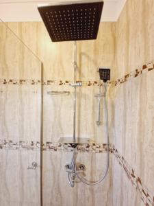 um chuveiro na casa de banho com uma cabeça de chuveiro em 5* Royal House near Unirii Square em Cluj-Napoca