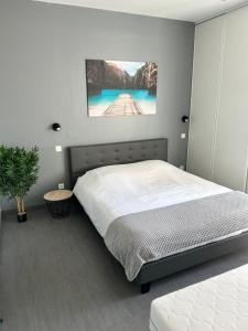 ein Schlafzimmer mit einem Bett und einem Wandgemälde in der Unterkunft Le Coin Vert in Hettange-Grande