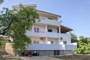 a white house with a motorcycle parked in front of it at Apartments Marković in Stari Grad