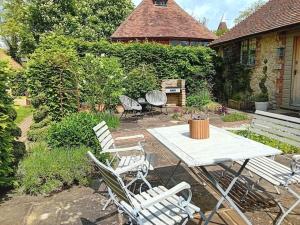 a patio with a white table and chairs at Weaver's Cottage in Smarden