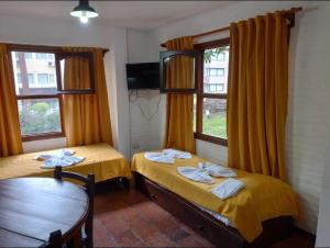 two beds in a room with two windows at San Remo Villa Corral Apart in Carilo