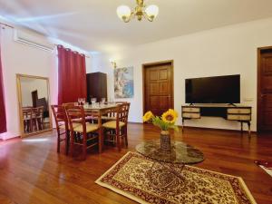 uma sala de estar com uma mesa e uma televisão em 5* Royal House near Unirii Square em Cluj-Napoca