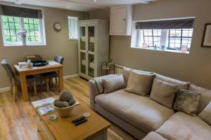 ein Wohnzimmer mit Sofa und Tisch in der Unterkunft Weaver's Cottage in Smarden