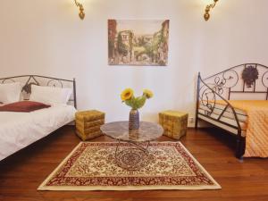 um quarto com duas camas e uma mesa com um vaso em 5* Royal House near Unirii Square em Cluj-Napoca
