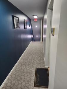 a long hallway with a tile floor and blue walls at The True The Archive Lofts in Marion