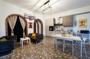 a living room with a table and a kitchen at Casa Pirri in Castelmola