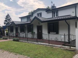 a white house with a black fence at W Starej Leśnej in Stegna