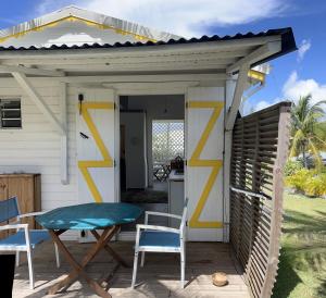 luifel boven een patio met een tafel en stoelen bij LES BUNGALOWS DE LOUISIANE in Saint-François