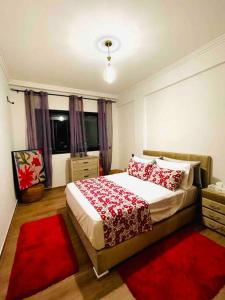 een slaapkamer met een groot bed met rode kussens bij Appartement luxueux au centre de marrakech in Marrakesh