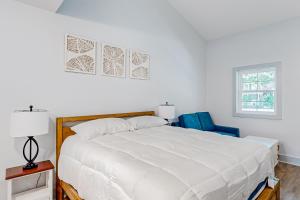 a bedroom with a large white bed and two blue chairs at Town of Rehoboth Beach - 99 Sussex St Unit #4 in Rehoboth Beach
