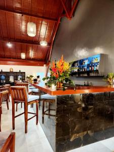 a bar in a restaurant with chairs and a counter at Andriana Resort & Spa in Nosy Be