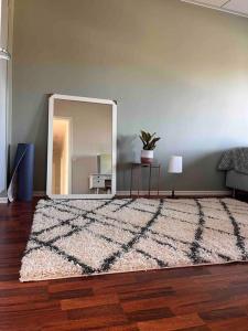 a living room with a mirror and a rug at A stylish, newly decorated home! in Raahe