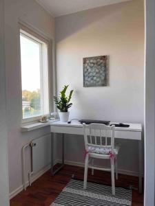 a white desk with a chair next to a window at A stylish, newly decorated home! in Raahe