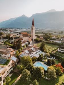 an aerial view of a small town with a church at Boutique-Hotel Ballguthof am Golfplatz in Lana