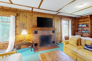 a living room with a fireplace and a tv at The Farmhouse Back House in Montpelier