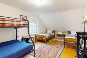 a bedroom with two bunk beds and a rug at The Farmhouse Back House in Montpelier