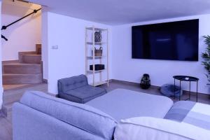 sala de estar con sofá y TV de pantalla plana en Alicantecity Jacuzzinema, en Alicante