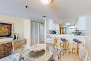 a dining room and kitchen with a glass table and chairs at The Sea Goose in Ormond Beach