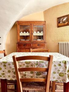 a dining room table with a wooden cabinet with dishes at B&B Terra di confine in Venalzio