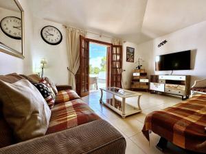 uma sala de estar com um sofá e uma televisão em The Escape, Golf del Sur em San Miguel de Abona