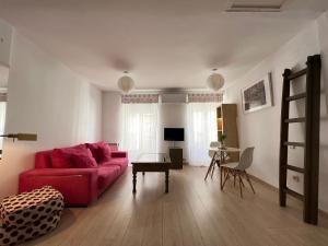 a living room with a red couch and a table at Lovely studio con balconcitos in Madrid