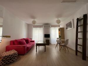 馬德里的住宿－Lovely studio con balconcitos，客厅配有红色的沙发和桌子