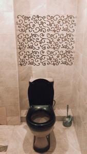 łazienka z czarną toaletą i ścianą w obiekcie Apartament Luka w Bordżomi