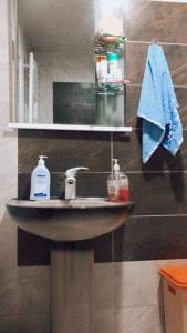 łazienka z umywalką i niebieskim ręcznikiem w obiekcie Apartament Luka w Bordżomi
