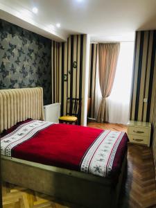 sypialnia z łóżkiem z czerwonym kocem w obiekcie Apartament Luka w Bordżomi