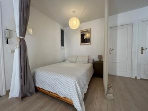 a white bedroom with a bed and a door at Lovely studio con balconcitos in Madrid
