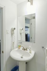 een badkamer met een witte wastafel en een spiegel bij Lakeside Inn in Orillia