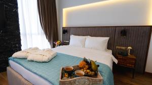 a hotel room with a bed with a tray of fruit on it at Kass Diamond Resort in Tsalka
