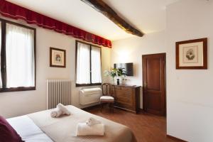 Un dormitorio con una cama, un escritorio y ventanas. en S. Spirito Studio Flat, en Florencia