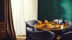 uma mesa com um prato de comida e dois copos de sumo de laranja em Kass Diamond Resort em Tsalka