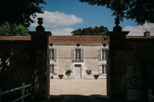 una vieja casa de piedra con una puerta delante de ella en Beautiful riverside boathouse, en Bourg-Charente