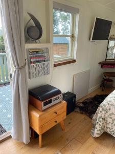 Un dormitorio con una cama y una radio en una mesa. en Muffins Meadow Shepherds Hut, en Tillingham