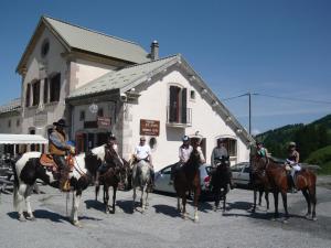 grupa ludzi jeżdżących konno przed budynkiem w obiekcie Hôtel, Le Refuge Napoléon w mieście Vars