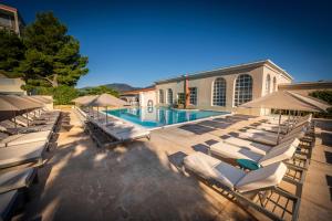 a group of lounge chairs and a swimming pool at C&ocirc;t&eacute; Thalasso H&ocirc;tel & Spa Marin in Banyuls-sur-Mer