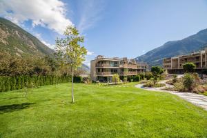 a tree in the middle of a yard with a building at Natur Romantik Apartment Annalena in Castelbello-ciardes