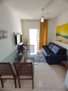 ein Wohnzimmer mit einem schwarzen Sofa und einem Glastisch in der Unterkunft Sweet Room Coroa Vermelha in Santa Cruz Cabrália