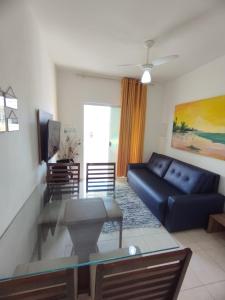 ein Wohnzimmer mit einem blauen Sofa und einem Glastisch in der Unterkunft Sweet Room Coroa Vermelha in Santa Cruz Cabrália