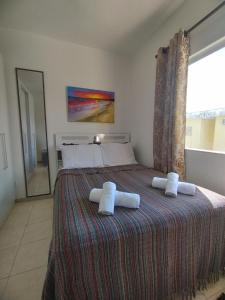 ein Schlafzimmer mit einem Bett mit zwei Handtüchern darauf in der Unterkunft Sweet Room Coroa Vermelha in Santa Cruz Cabrália