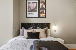 a bedroom with a large bed with four pictures on the wall at Stunning Central Wakefield Apartment 2 - Parking in Wakefield