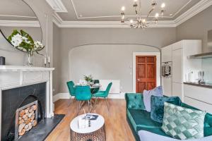 a living room with a fireplace and a green couch at Lovely Central Wakefield Apartment - Parking in Wakefield
